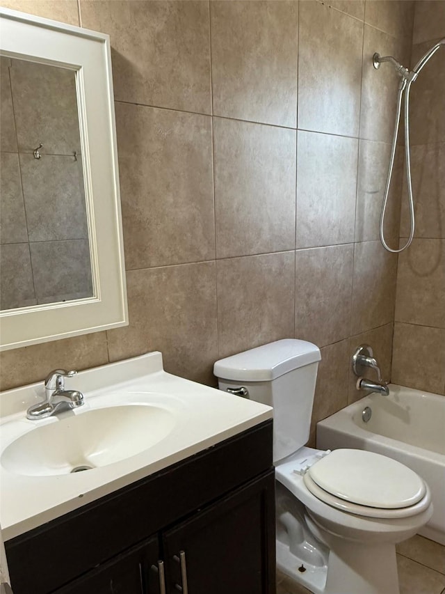 bathroom featuring tile walls, bathtub / shower combination, toilet, vanity, and tile patterned floors