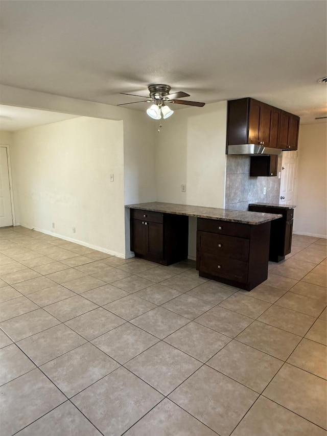 kitchen with dark brown cabinetry, ceiling fan, baseboards, and backsplash