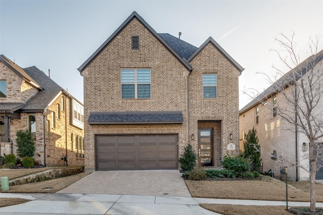 view of front of property featuring driveway, a shingled roof, a garage, and brick siding