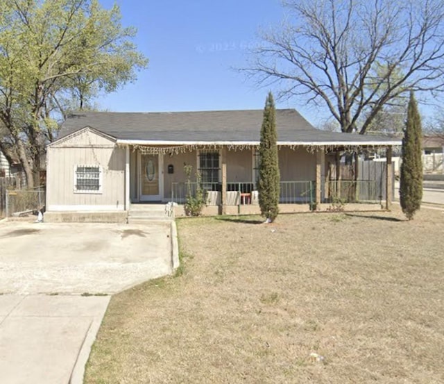 view of front of property with driveway, fence, a porch, and a front yard