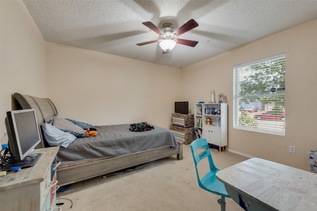 bedroom featuring light carpet, a ceiling fan, and a textured ceiling