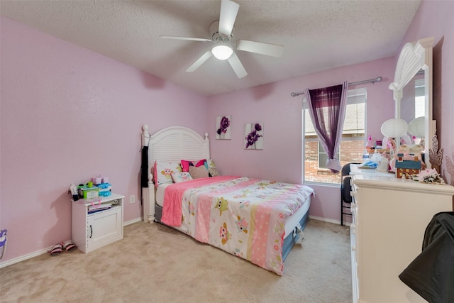 bedroom featuring light carpet, ceiling fan, a textured ceiling, and baseboards