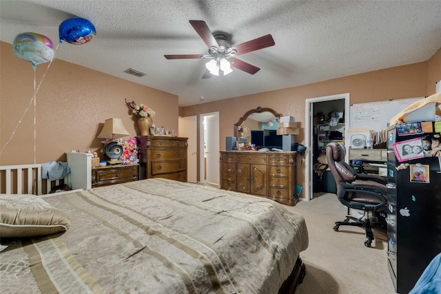 bedroom featuring light carpet, visible vents, a textured ceiling, and a textured wall