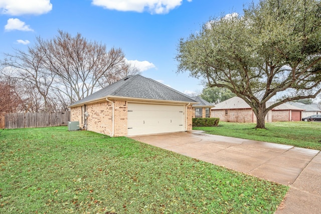 view of home's exterior with a yard, concrete driveway, brick siding, and fence