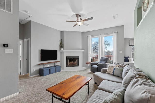 living area with attic access, light carpet, ceiling fan, and visible vents