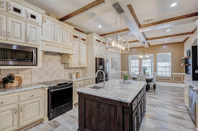 7101 Bridges Ave, Richland Hills, TX 76118 - kitchen with glass insert cabinets, decorative light fixtures, cream cabinets, stainless steel appliances, and a sink