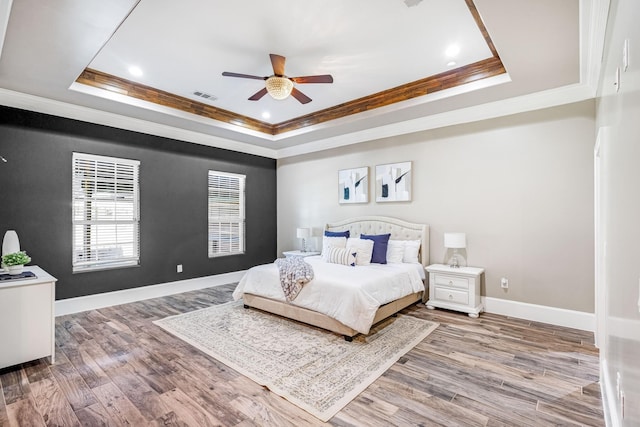 7101 Bridges Ave, Richland Hills, TX 76118 - bedroom featuring ornamental molding, a tray ceiling, visible vents, and wood finished floors