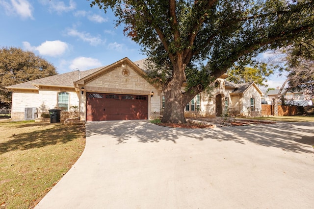 7101 Bridges Ave, Richland Hills, TX 76118 - view of front facade with an attached garage, central AC, stone siding, driveway, and a front yard