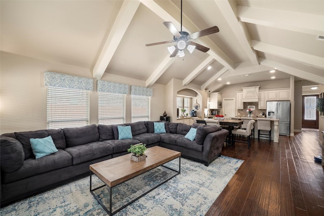 living room with lofted ceiling with beams, ceiling fan, plenty of natural light, and dark wood finished floors