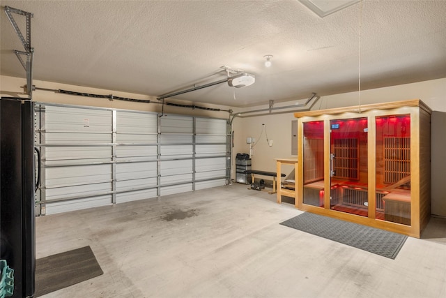 garage with a garage door opener, freestanding refrigerator, and electric panel