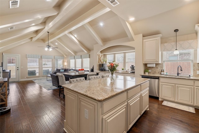 kitchen featuring visible vents, dishwasher, a kitchen island, open floor plan, and hanging light fixtures