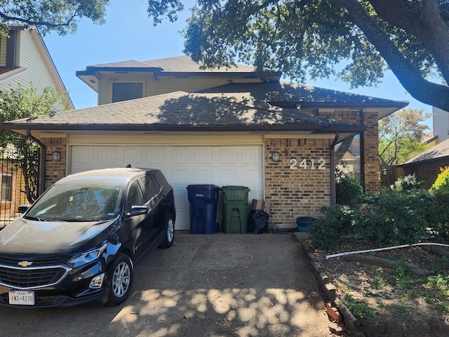 exterior space featuring a garage, driveway, brick siding, and a shingled roof