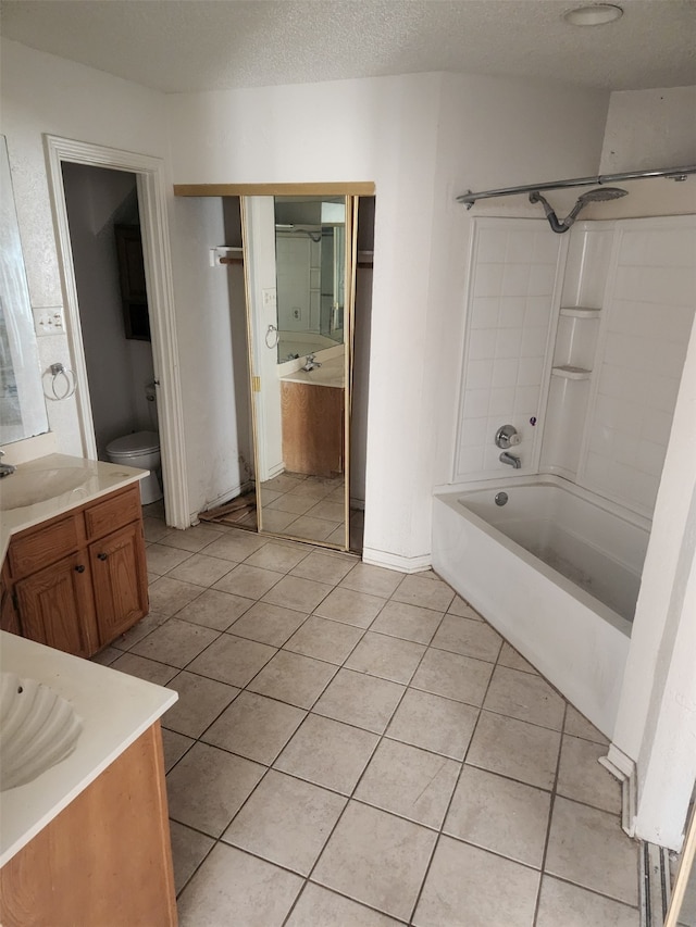 bathroom with toilet, washtub / shower combination, a textured ceiling, vanity, and tile patterned floors