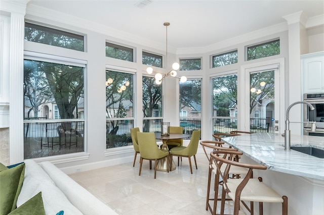 sunroom / solarium featuring visible vents, a sink, and an inviting chandelier