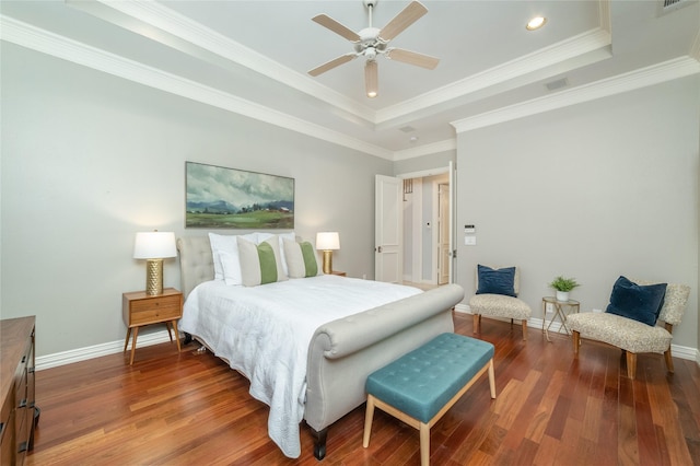 bedroom with crown molding, baseboards, a raised ceiling, and wood finished floors