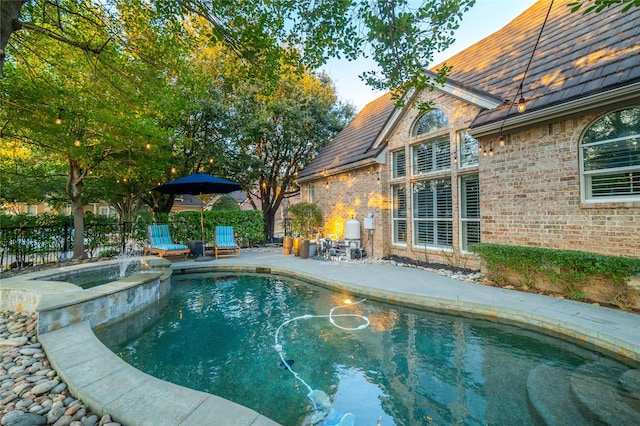 view of swimming pool featuring an in ground hot tub, a patio, fence, and a fenced in pool