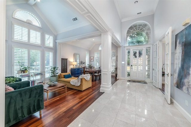 entryway with high vaulted ceiling, visible vents, crown molding, and light tile patterned floors