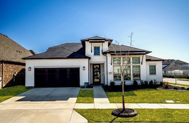 view of front of home featuring a shingled roof, a front lawn, concrete driveway, stucco siding, and a garage