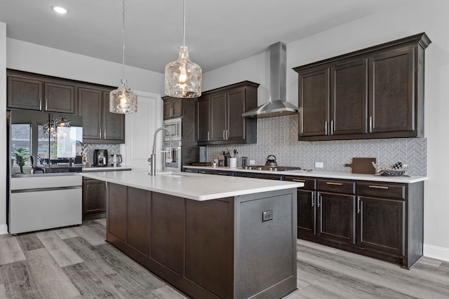 1305 Redbrick Ln, Northlake, TX 76247 - kitchen with wall chimney range hood, appliances with stainless steel finishes, dark brown cabinetry, a sink, and backsplash