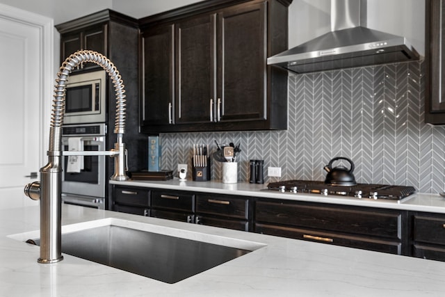 1305 Redbrick Ln, Northlake, TX 76247 - kitchen featuring wall chimney exhaust hood, appliances with stainless steel finishes, tasteful backsplash, and light stone counters