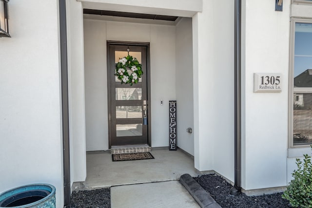 property entrance with stucco siding