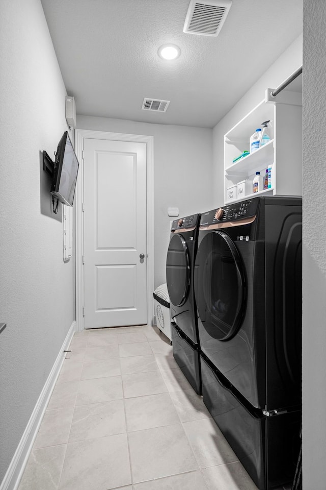 1305 Redbrick Ln, Northlake, TX 76247 - washroom featuring washer and clothes dryer, a textured ceiling, light tile patterned flooring, and baseboards
