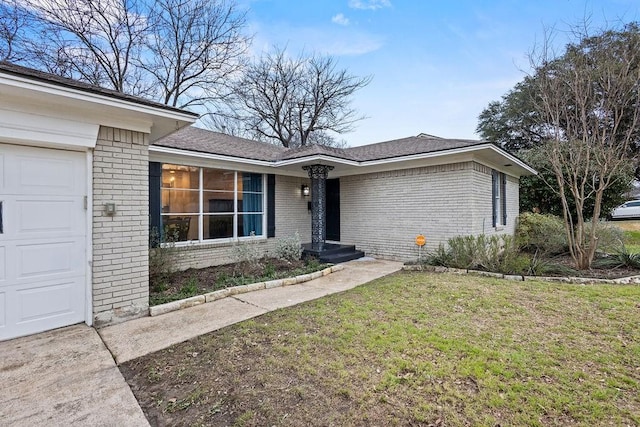 ranch-style house featuring brick siding, a front lawn, and an attached garage