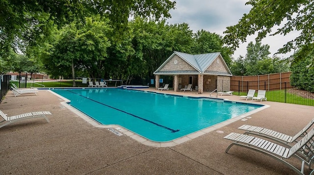 community pool featuring fence and a patio