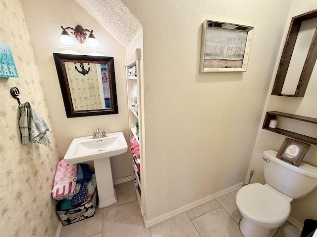 bathroom with tile patterned flooring, toilet, and baseboards