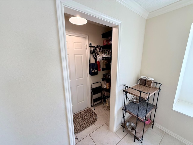 interior space with baseboards, light tile patterned flooring, and crown molding