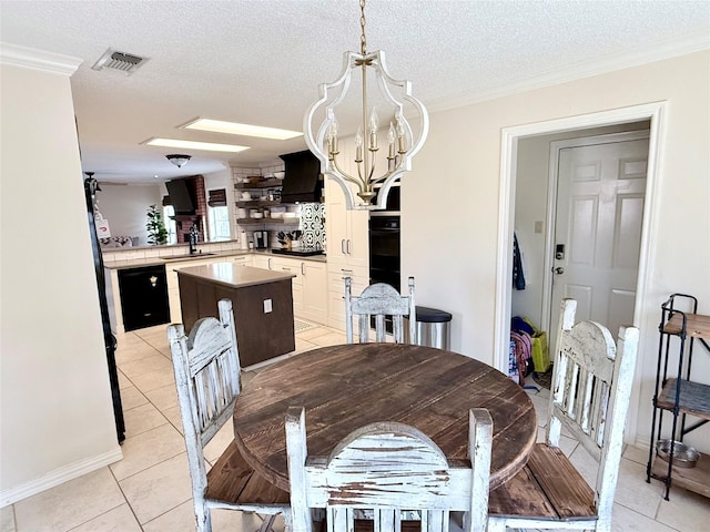 dining room with a textured ceiling, light tile patterned floors, visible vents, and a notable chandelier