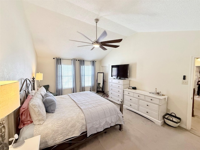 bedroom with vaulted ceiling, ceiling fan, a textured ceiling, and light colored carpet