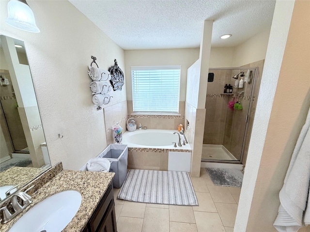 bathroom with a garden tub, a stall shower, a textured ceiling, vanity, and tile patterned floors