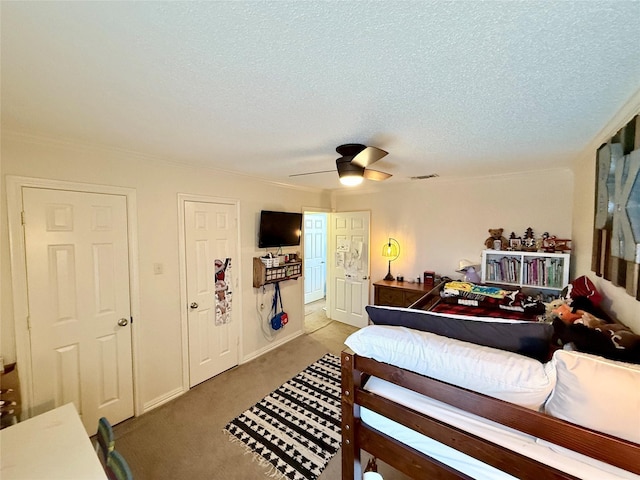 bedroom featuring a textured ceiling, carpet floors, ceiling fan, and visible vents