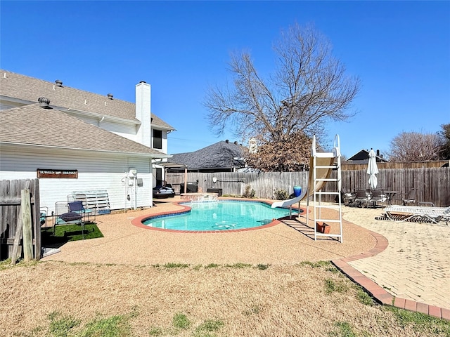 view of swimming pool featuring a fenced in pool, a water slide, a patio area, and a fenced backyard