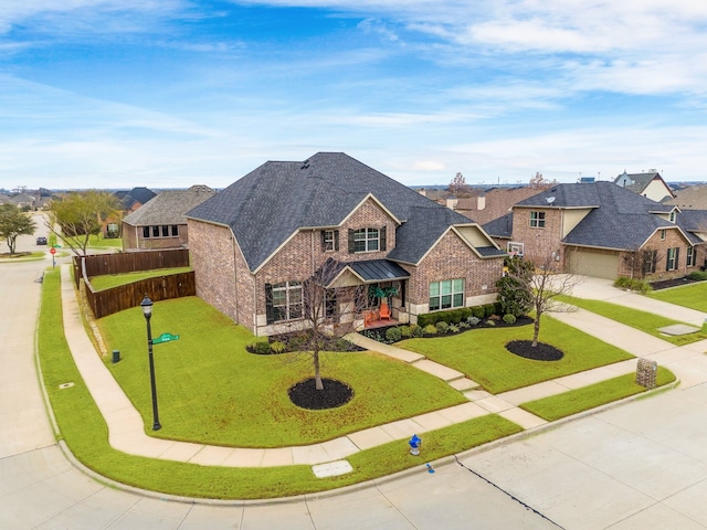 view of front of property with driveway, a front yard, fence, and brick siding