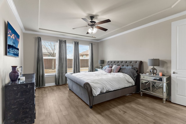 bedroom featuring ceiling fan, wood finished floors, and crown molding