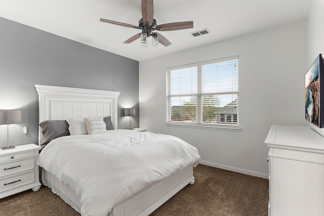 bedroom with ceiling fan, dark carpet, visible vents, and baseboards