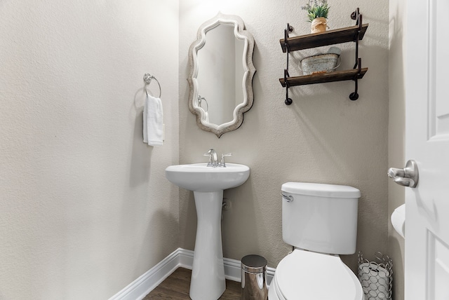 bathroom featuring wood finished floors, toilet, and baseboards