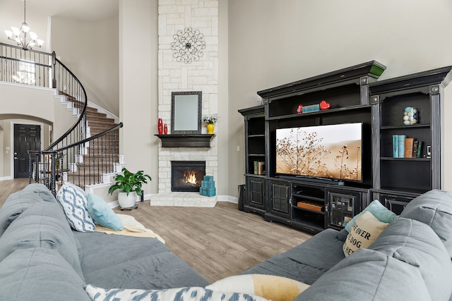 living area featuring a chandelier, a high ceiling, stairway, and wood finished floors