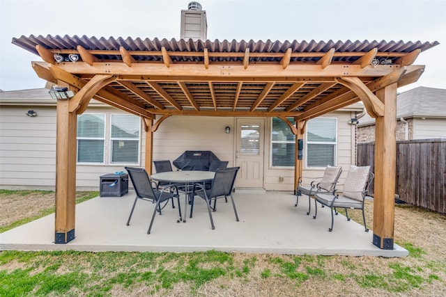 view of patio featuring outdoor dining area and fence