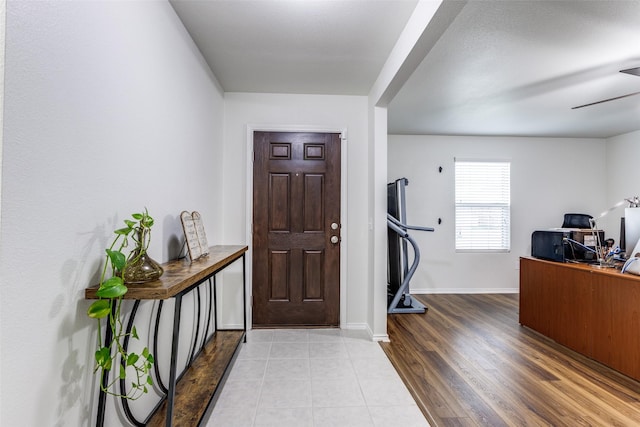 entryway with ceiling fan, light wood-type flooring, and baseboards