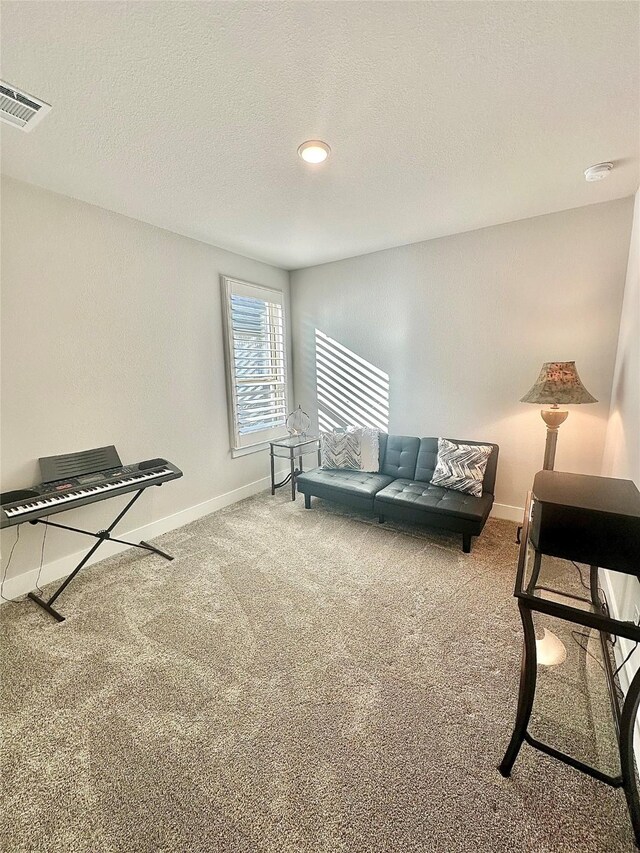 living area with carpet, visible vents, a textured ceiling, and baseboards