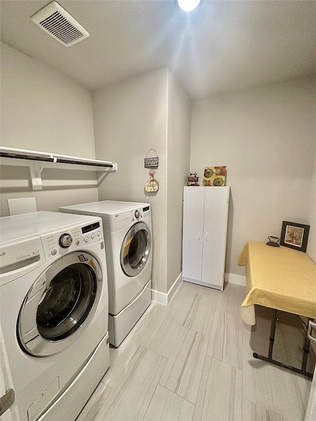 laundry area featuring laundry area, baseboards, visible vents, and washing machine and clothes dryer