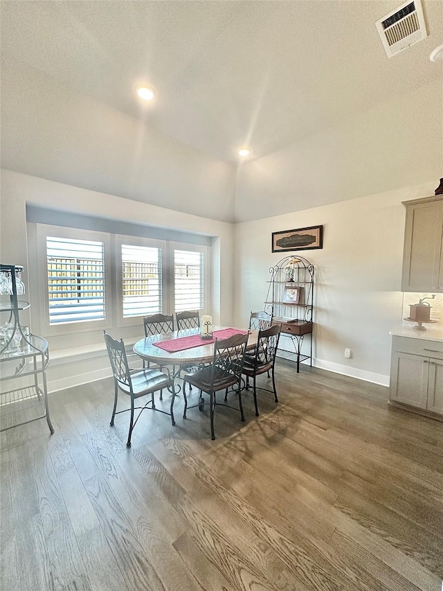 dining space with baseboards, visible vents, lofted ceiling, wood finished floors, and recessed lighting