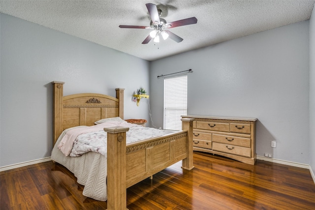 bedroom with baseboards, dark wood finished floors, and a textured ceiling