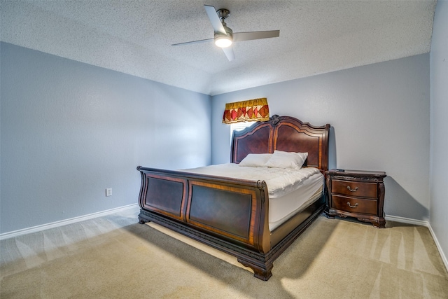 bedroom featuring light carpet, a textured ceiling, a ceiling fan, and baseboards