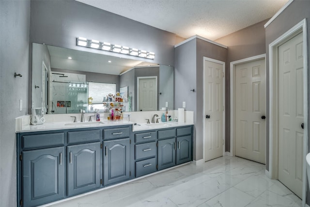 full bath featuring double vanity, a stall shower, marble finish floor, a textured ceiling, and a sink