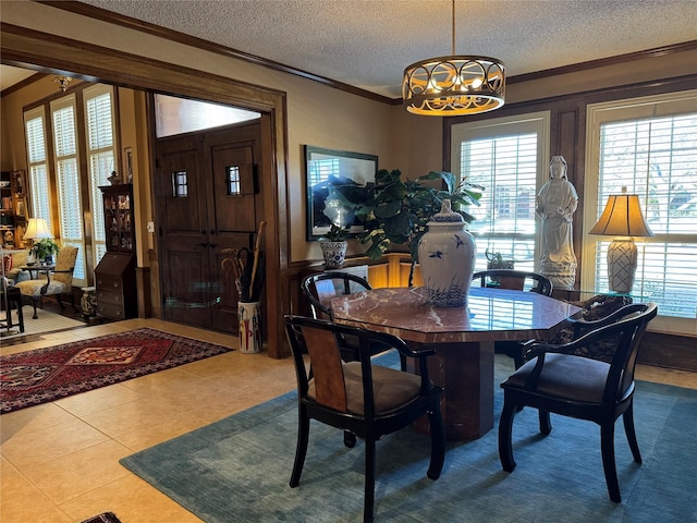 dining area featuring a notable chandelier, a textured ceiling, and crown molding