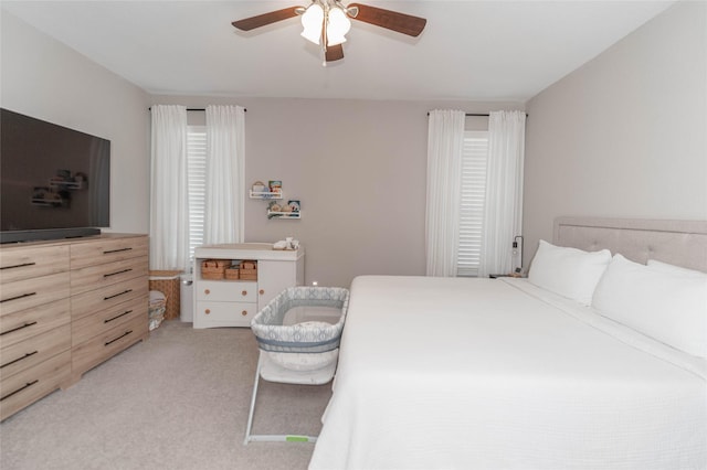 bedroom with a ceiling fan and light carpet